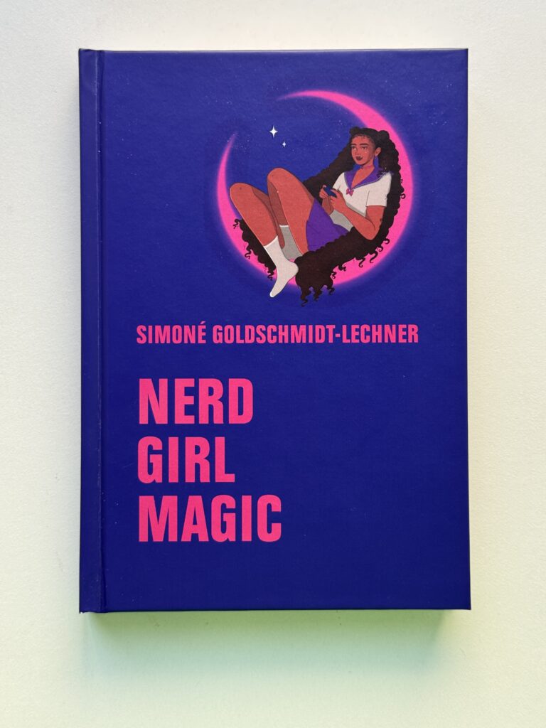 Foto vom Buch auf weißem Hintergrund. Blaues Cover, pinke Schrift, über dem Titel sitzt eine Frau in einer Mondsichel, sie trägt Sailor Moon Kleidung